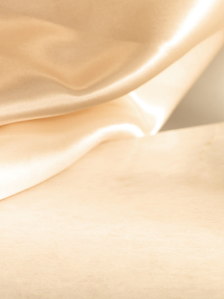 Close-up of beige satin fabric with a soft texture