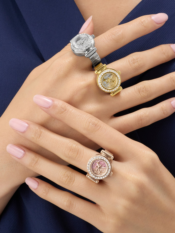 Three ornate rings on a person's hand against a dark background
