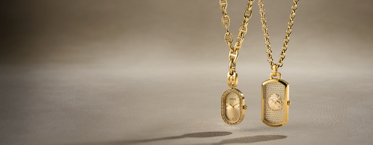 Two gold necklaces with oval and rectangular pendant charms hanging against a soft beige background.