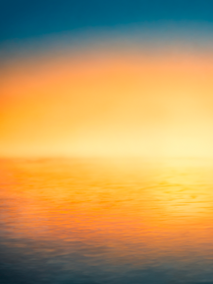 Abstract landscape art print featuring a gradient sunset over water, with vibrant orange and yellow hues reflecting on the water's surface against a deep blue sky.