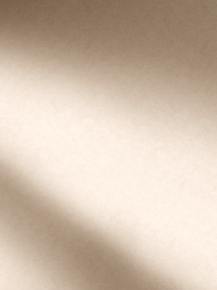 A close-up of a warm beige or cream textured surface with soft diagonal shadows across the lower-left area.