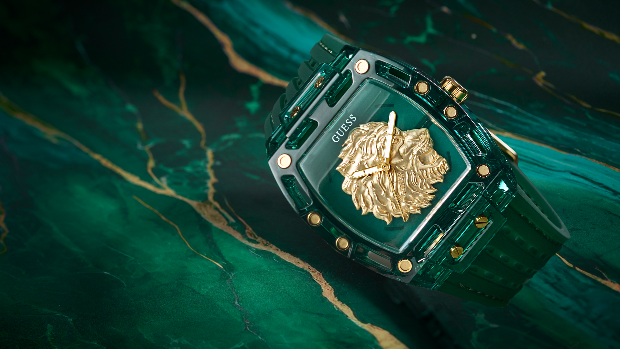 Green watch with gold accents on a dark green marble surface