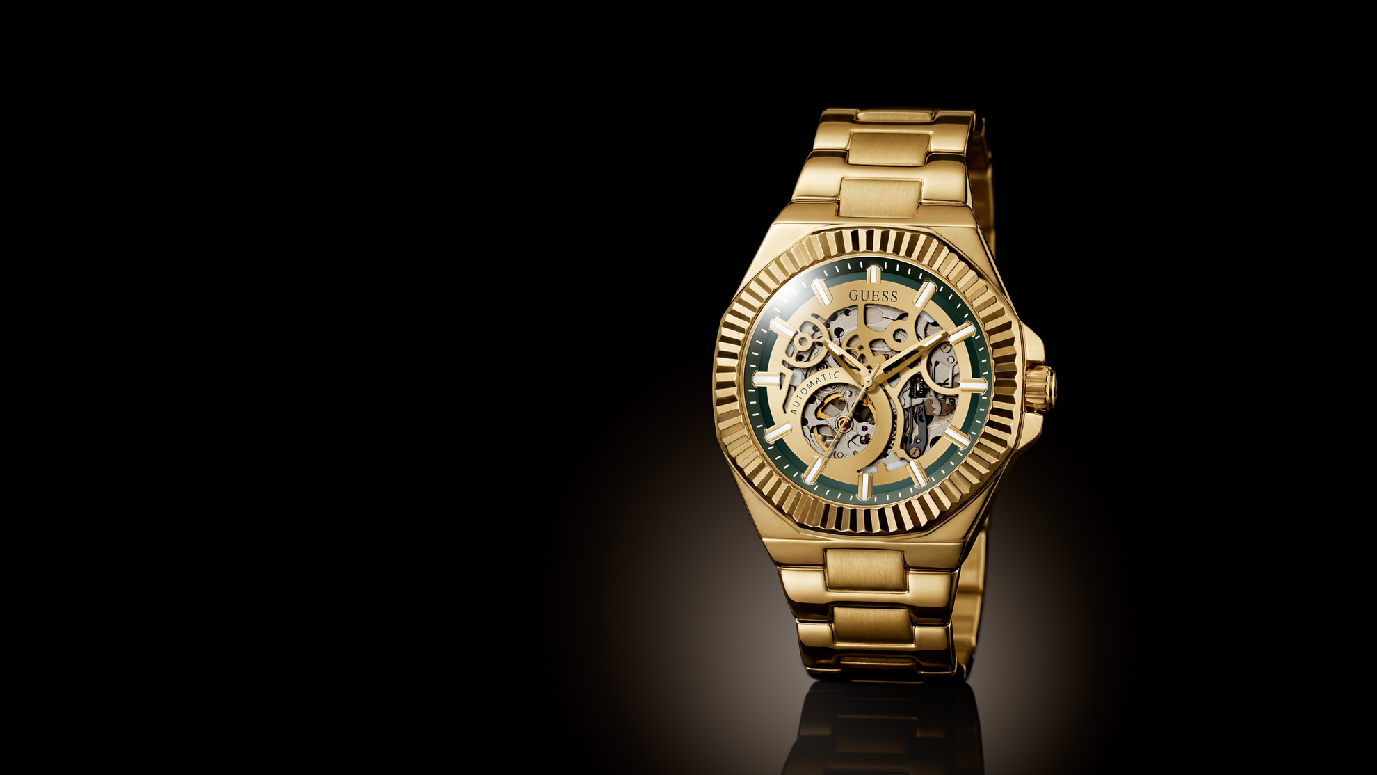 A luxury gold-tone wristwatch with a skeleton dial and green accents, positioned on the right side against a solid black background with a subtle reflection below.