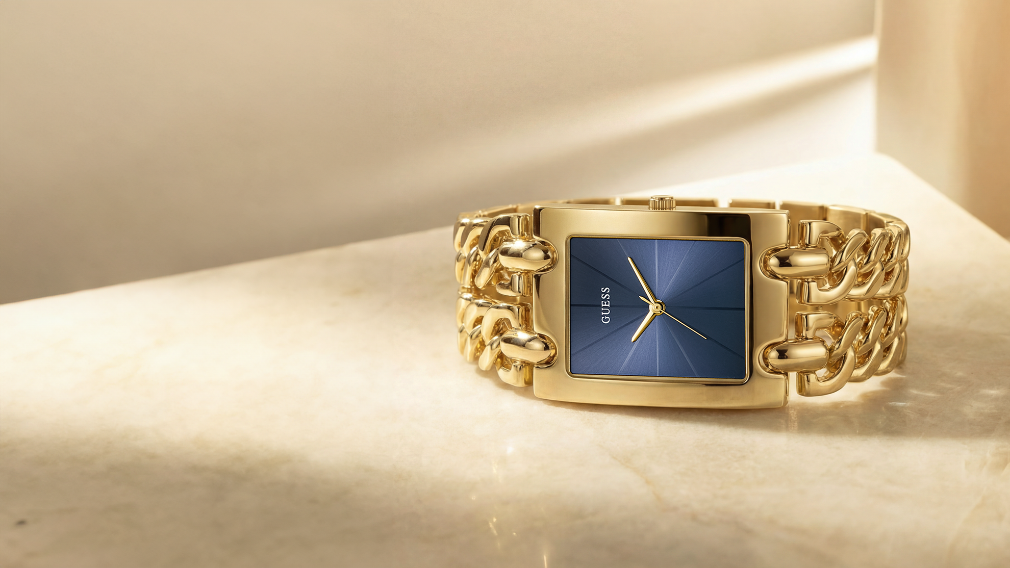 Gold watch with a blue face on a beige background