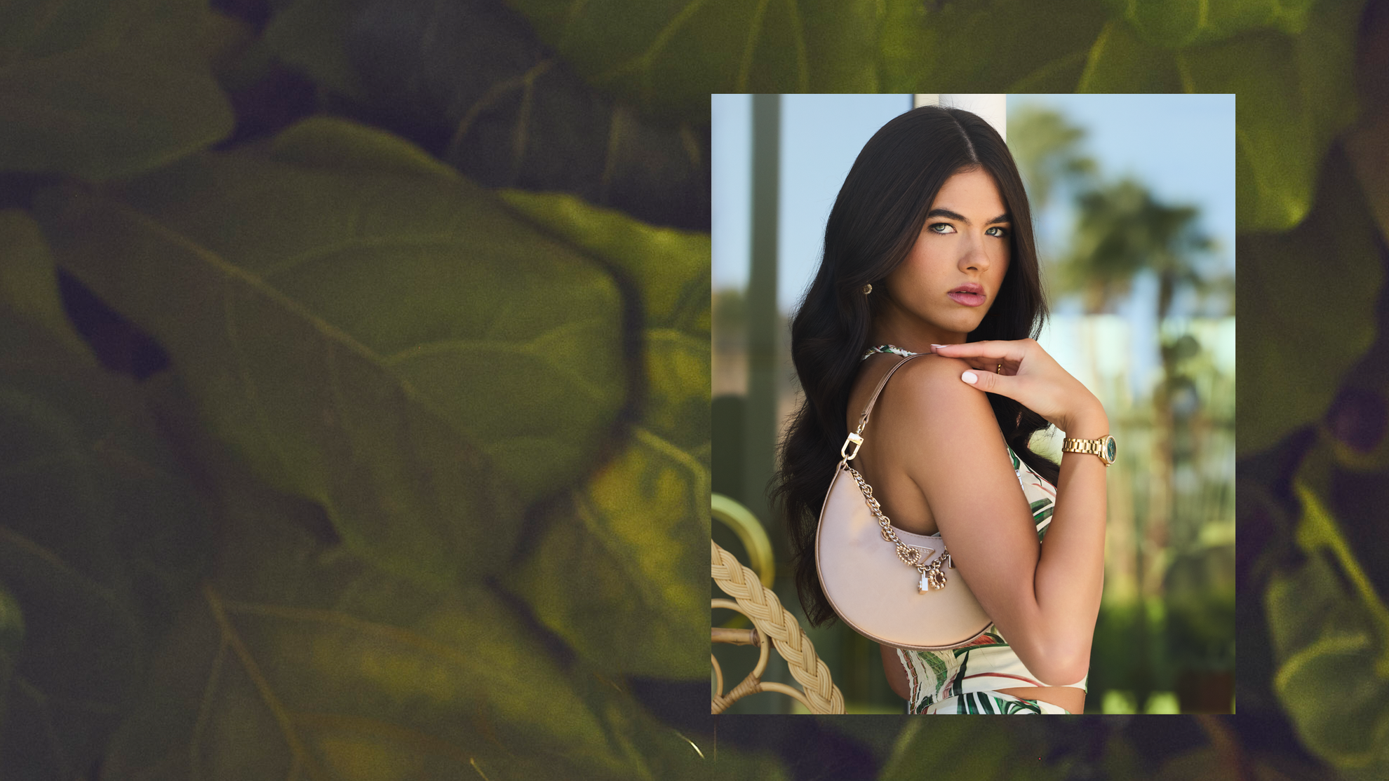 woman wearing a gold Guess watch standing on front of palm trees
