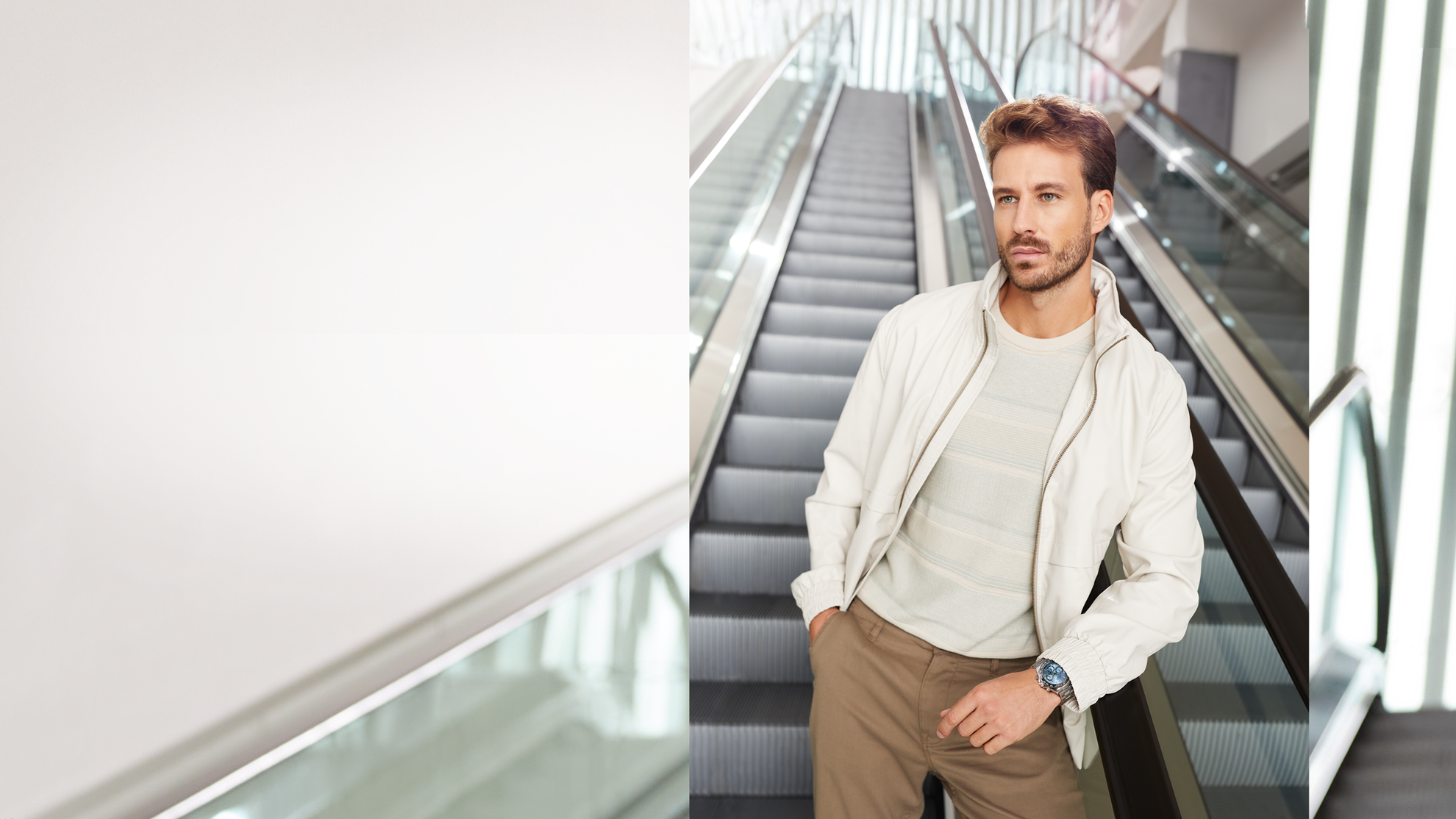 man standing on escalator stairs wearing a silver GUESS watch