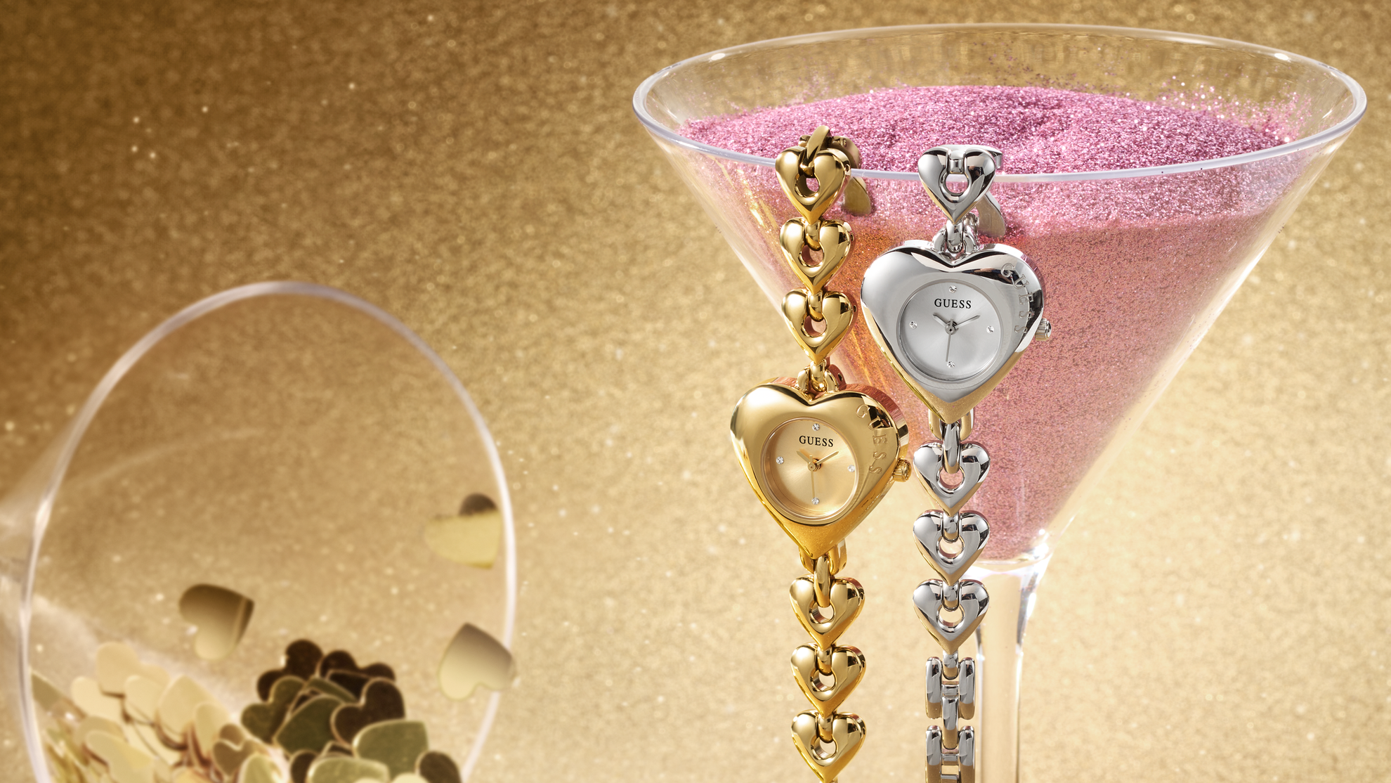 Womens silver and gold GUESS Watches with heart shaped cases on a gold background