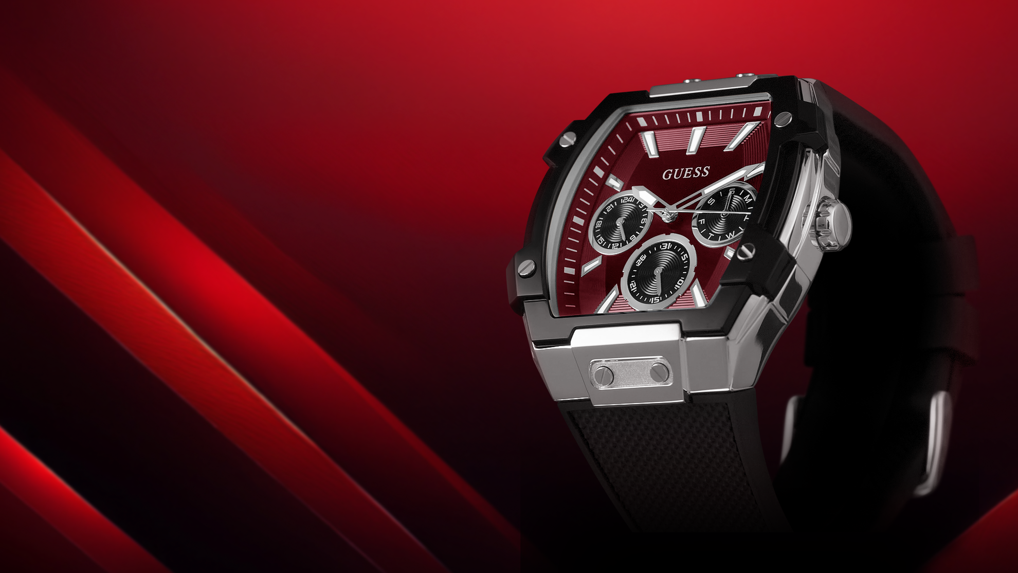Angled view of a GUESS watch with red face and black strap on a red background