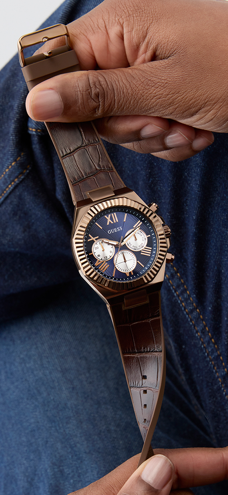 Man holding watch with brown leather strap and blue dial GW0791G4