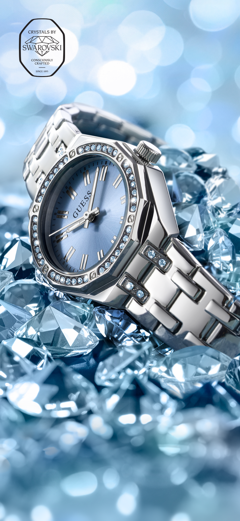 Silver watch with gemstone accents on a blue gemstone background with Swarovski seal in upper left