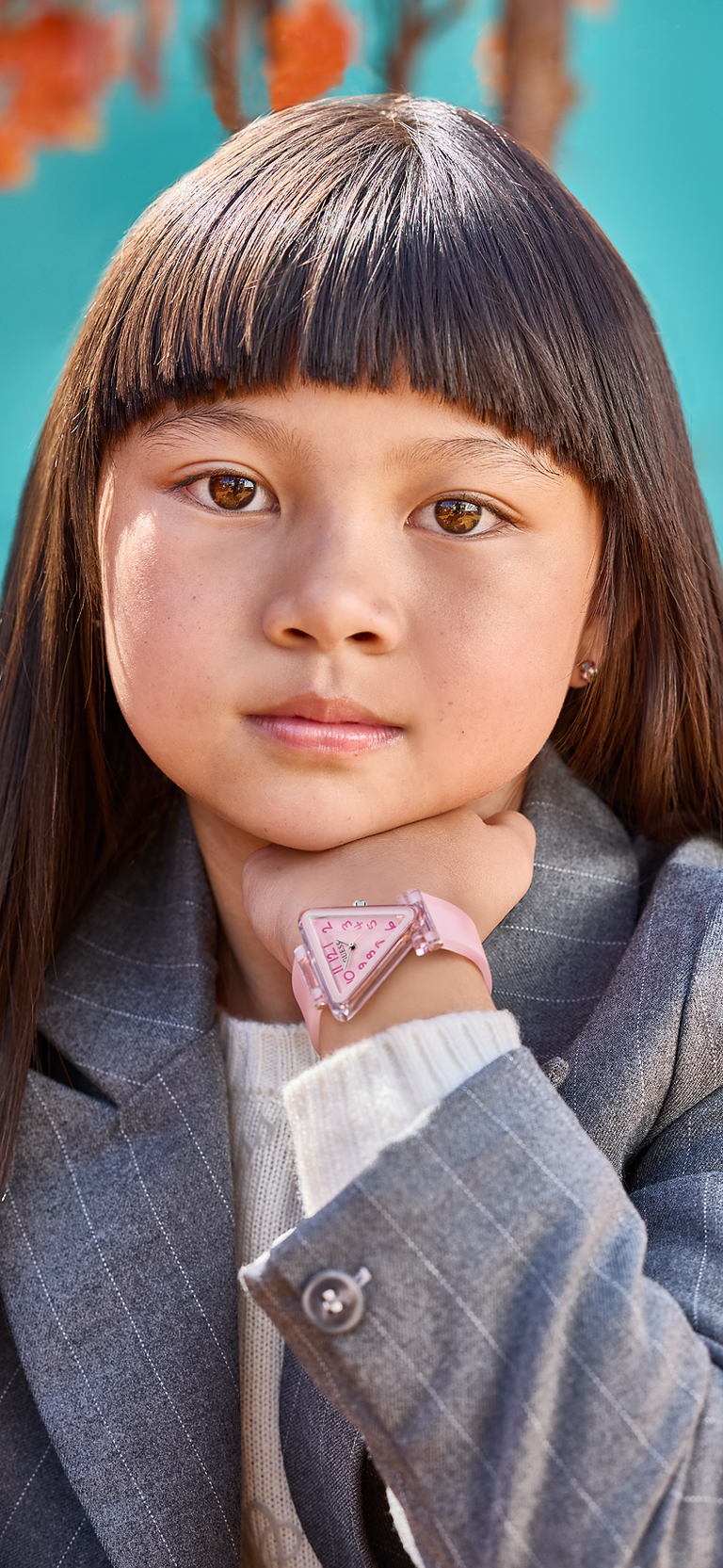 young girl wearing a pink guess triangle watch