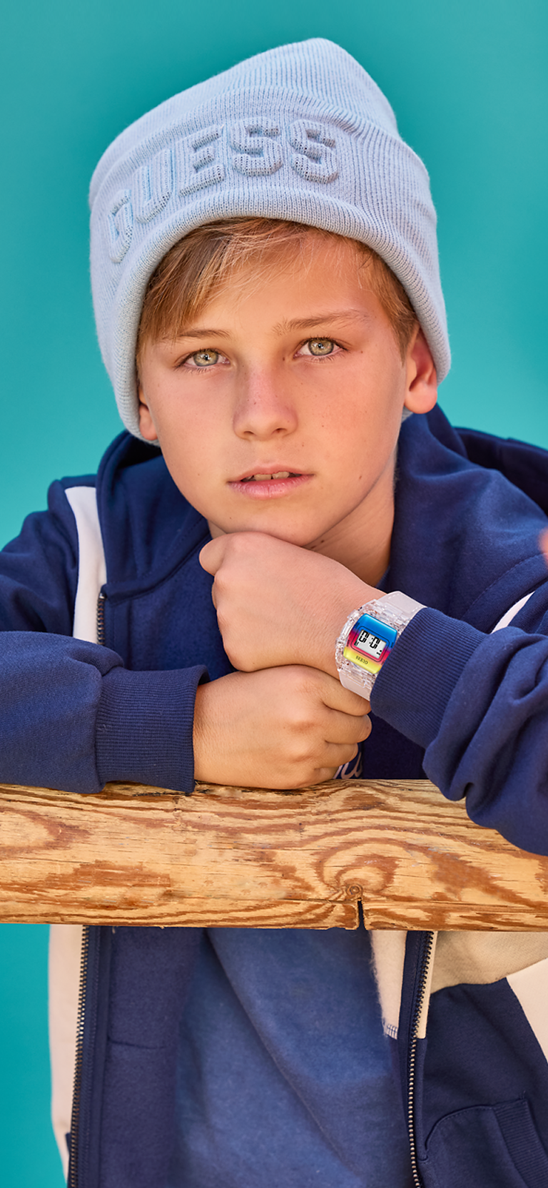 young boy wearing colorful guess watch