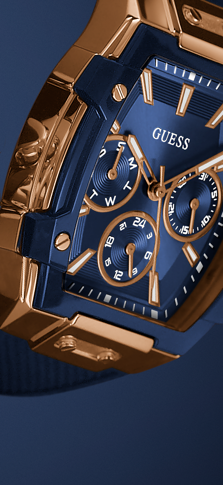 Gold and blue watch with 'Guess' branding on a dark background 