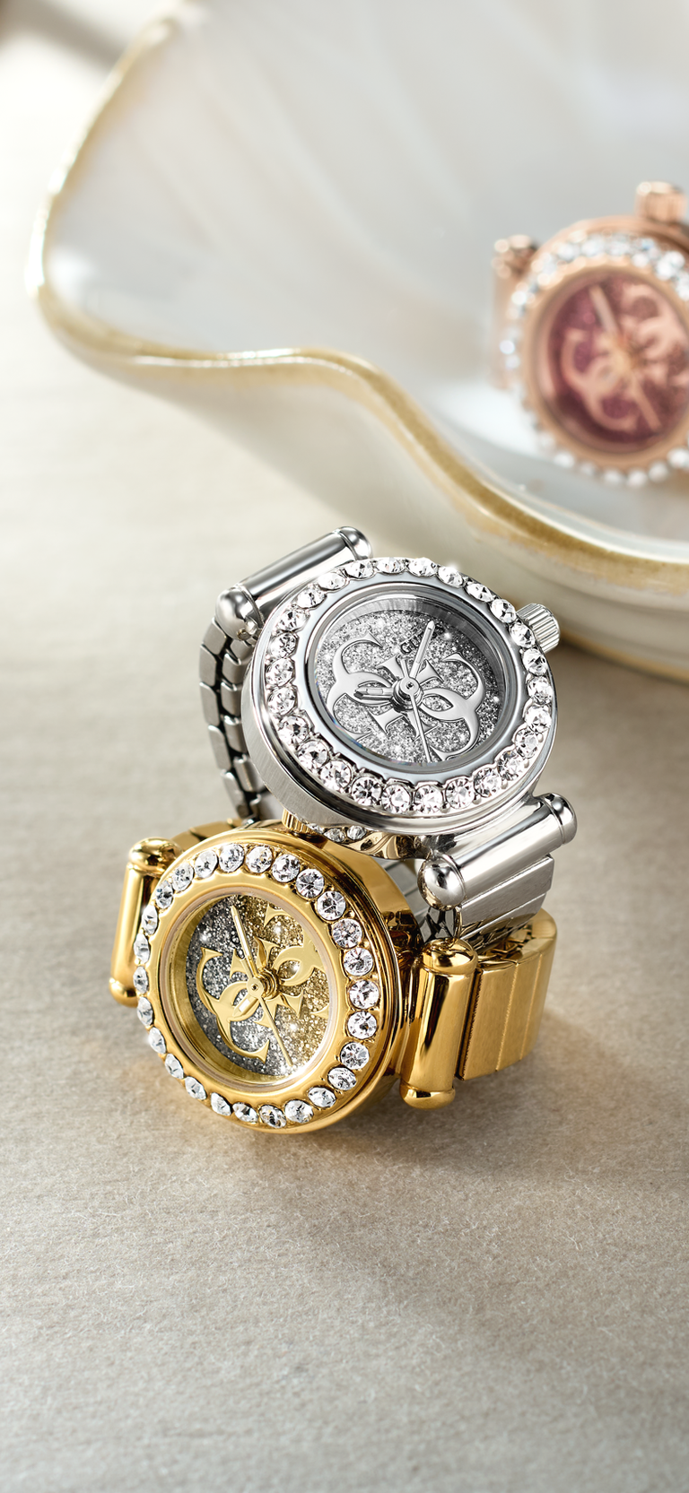 Two ornate watch rings with intricate designs on a light background