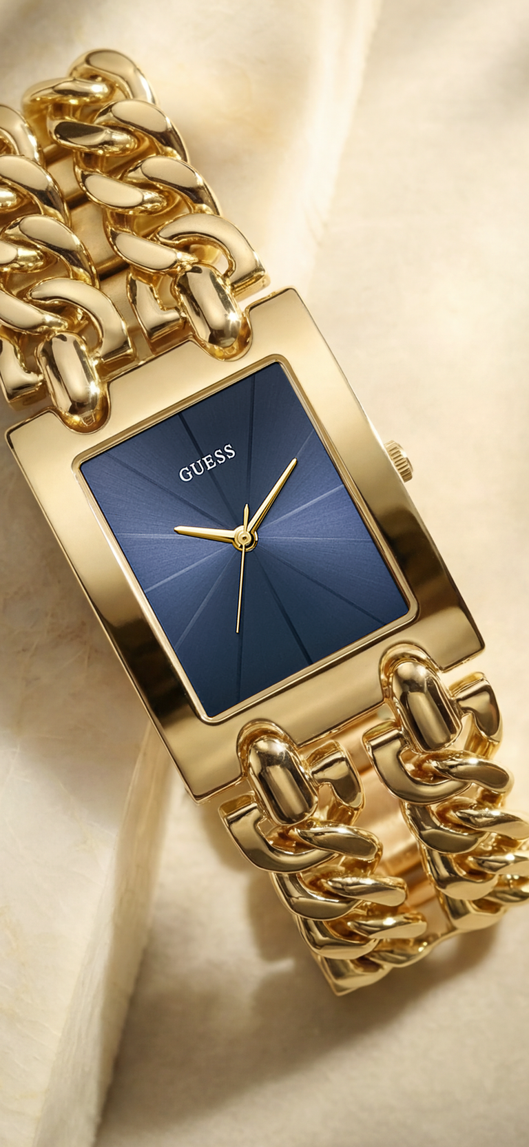 Gold watch with blue face on a beige background
