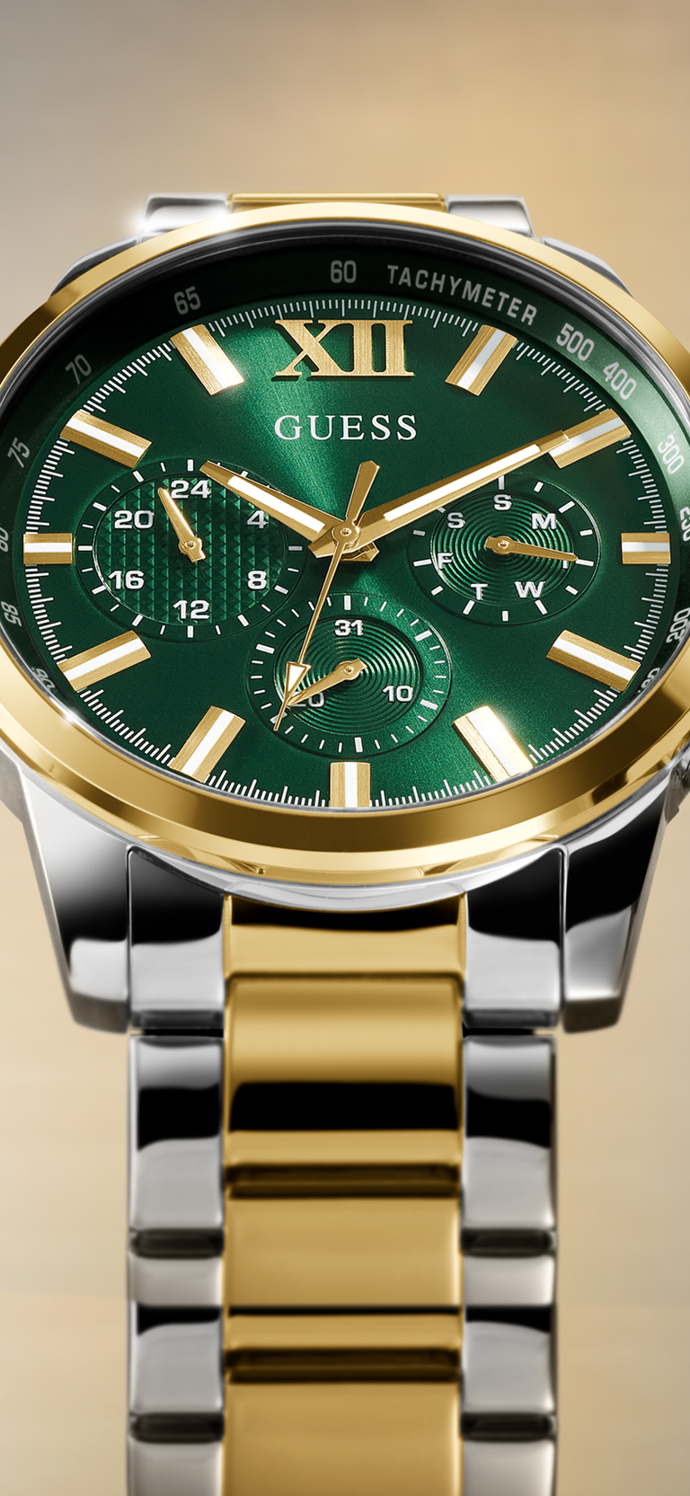 Close up of Gold and silver watch with green dial on a gold background