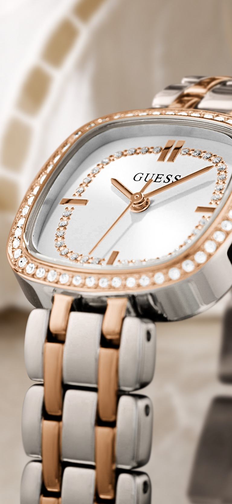 Guess watch with rose gold and silver band on a blurred background GW1018L5