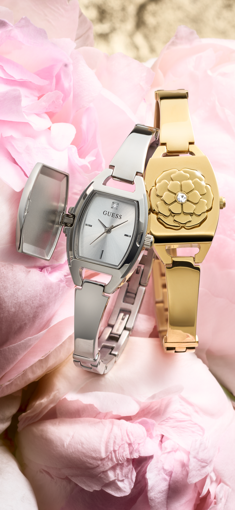 Two watches, one silver and one gold, on pink floral background