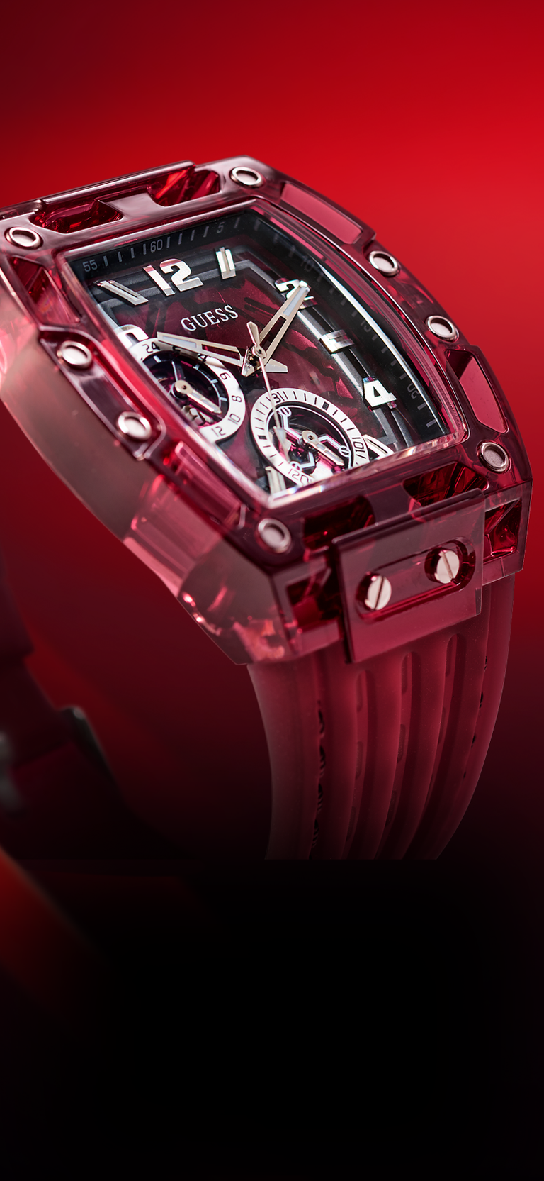 Angled view of a Red Guess watch with a clear face on a red background gw0499g12