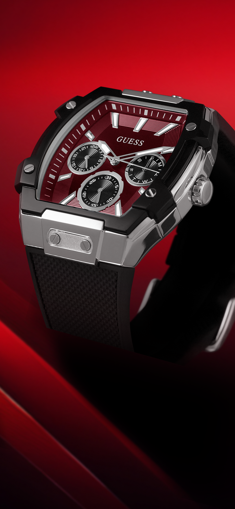 Angles view of a Black and silver watch with red face on a red background