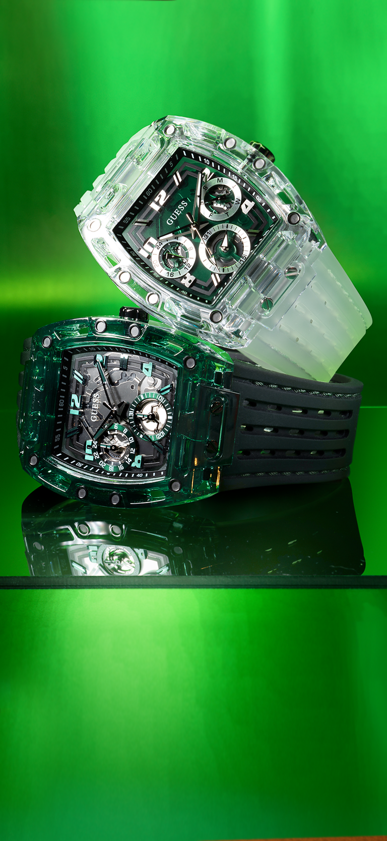 Two transparent watches with black straps on a green background gw0499g8