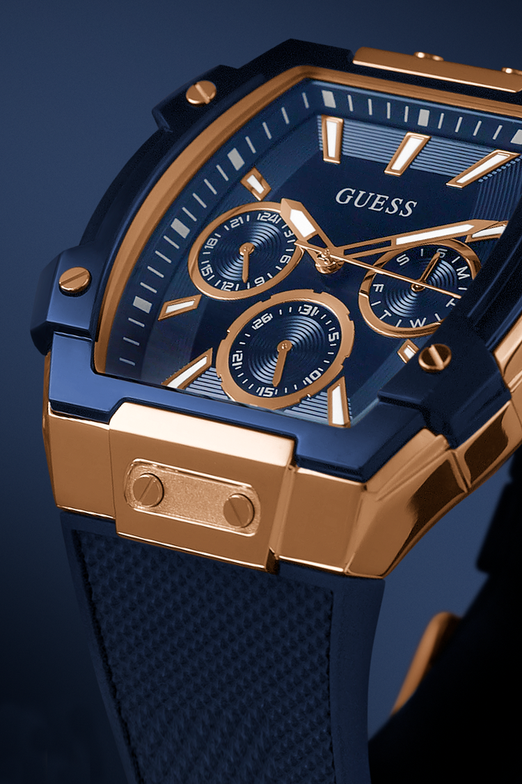 Blue and gold Guess watch with detailed face on a dark background