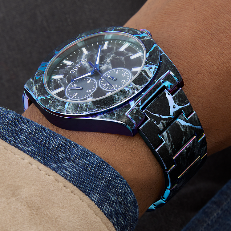 GUESS watch with a unique design on a wrist, featuring a dark background.