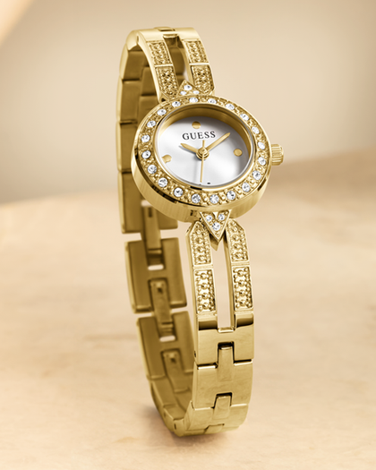 Gold watch with diamond accents on a beige background