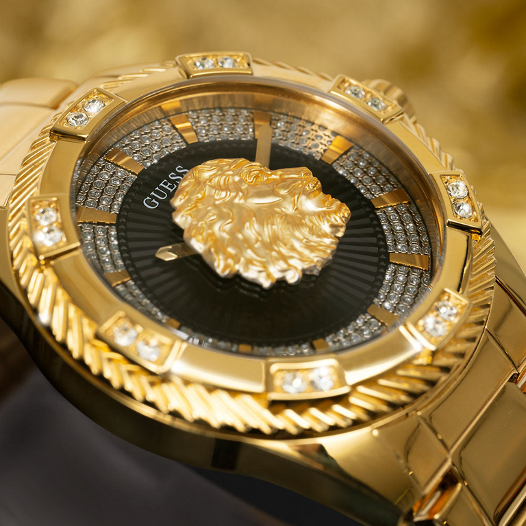 close up of mens gold watch with lions head logo on dial