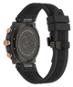 The back view of a Gc One 20th Anniversary Limited Edition Chronograph watch with a black textured silicone strap, a dark gray carbon fiber case, and rose gold accents on the side buttons and crown.