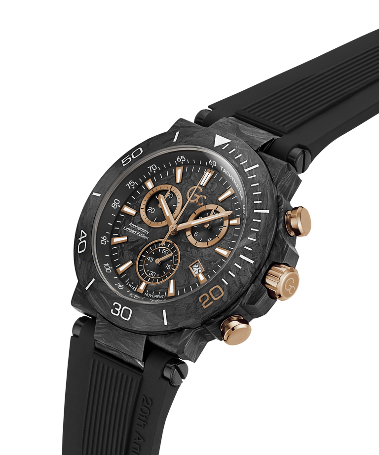 A carbon fiber chronograph watch with a black dial, black bezel, and a black rubber strap, accented with rose gold-tone hands, markers, and pushers. lifestyle