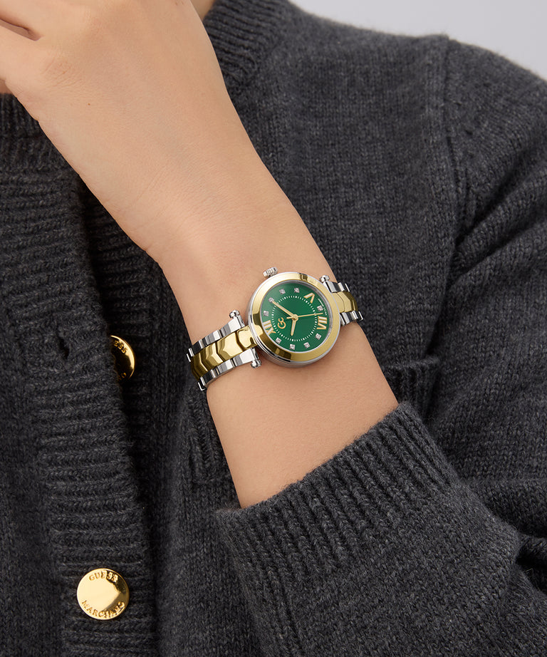Gc Illusion Small Size Metal Green watch with gold accents on a person's wrist wearing a dark gray sweater.
