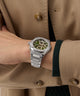 Gc Coussin Shape Chrono Metal Silver watch on a wrist with a beige coat background
