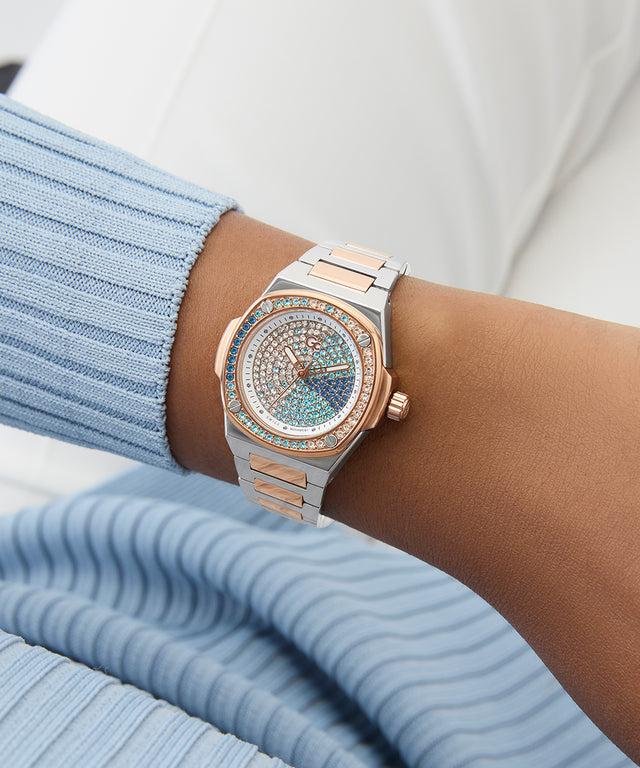 Gc Coussin Shape Mini Small Size Metal watch with a detailed face on a wrist, wearing a light blue ribbed sweater.