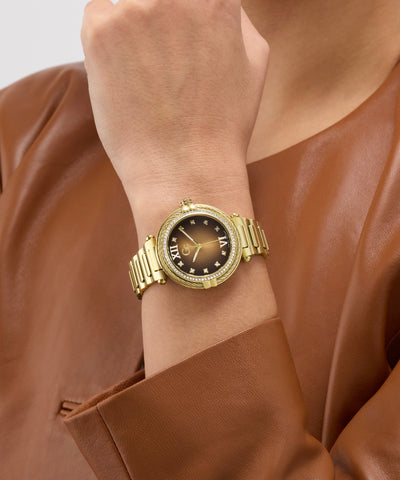 Gold Gc Vogue Cable Mid Size Metal watch on a wrist with a brown leather jacket