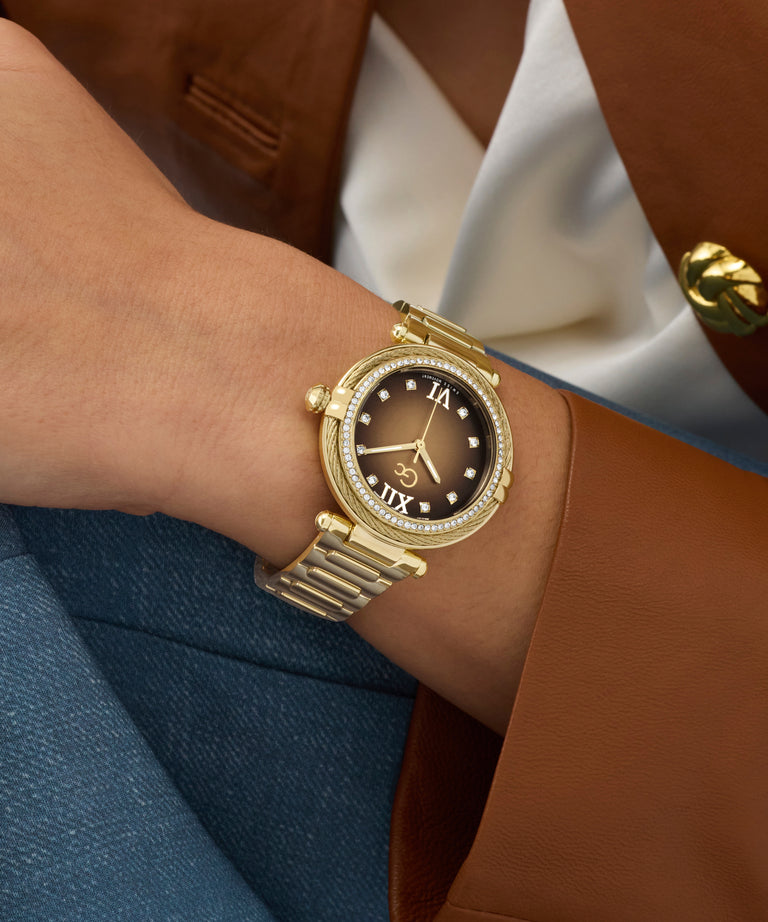 Gold Gc Vogue Cable Mid Size Metal watch on a wrist with a person wearing a brown blazer and white shirt.