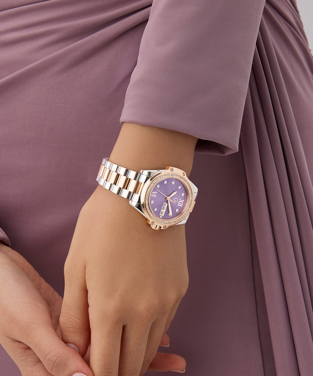Gc Bolt Lady Mid Size Metal Gold watch on a wrist with a blurred purple background