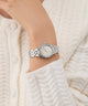 Gc Gleam Mini Small Size Metal Silver watch on a wrist with a white textured background