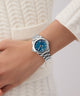 Gc Bolt Lady Mini Small Size Metal Silver watch with blue face on a wrist against a white textured background