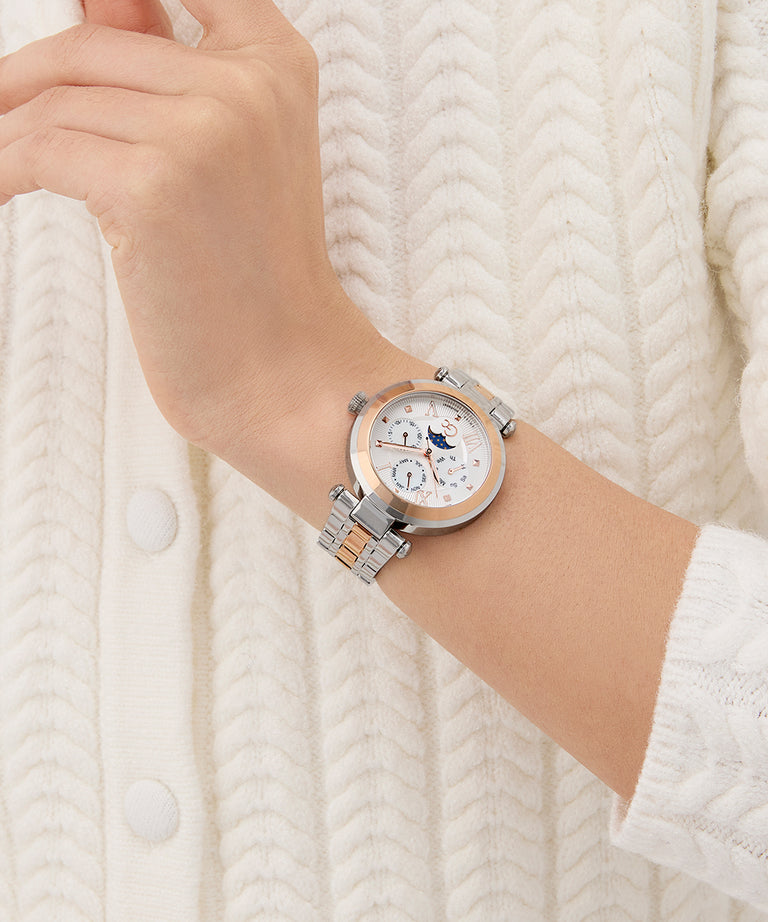 Wrist wearing a Gc TopChic Large Size Metal silver watch with a detailed face against a white textured background