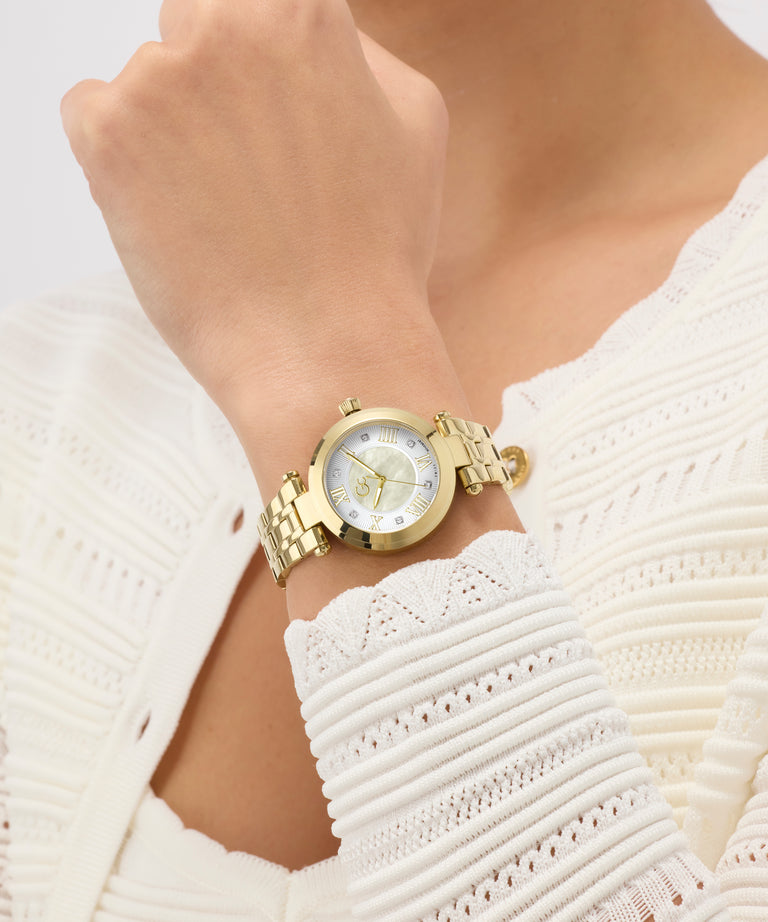 Gold Gc TopChic Mid Size Metal watch on a wrist with a white textured garment
