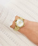 Gold Gc TopChic Mid Size Metal watch on a wrist against a white textured background