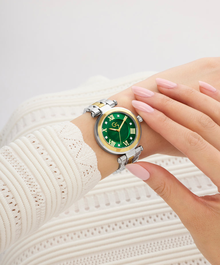 Gc TopChic Mid Size Metal Wristwatch with green face and gold accents on a wrist wearing a white textured sleeve.
