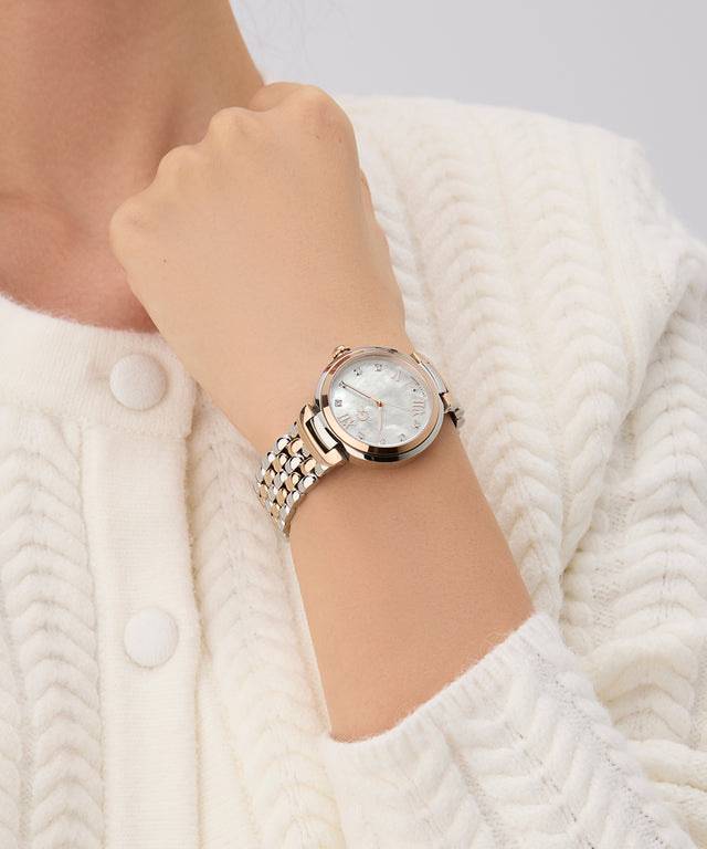 Gc Allure Mid Size Metal Silver watch on a wrist with a white textured background