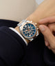 Close-up of a wrist wearing a silver and rose gold Gc Atlas Chrono Metal watch with a blue face.