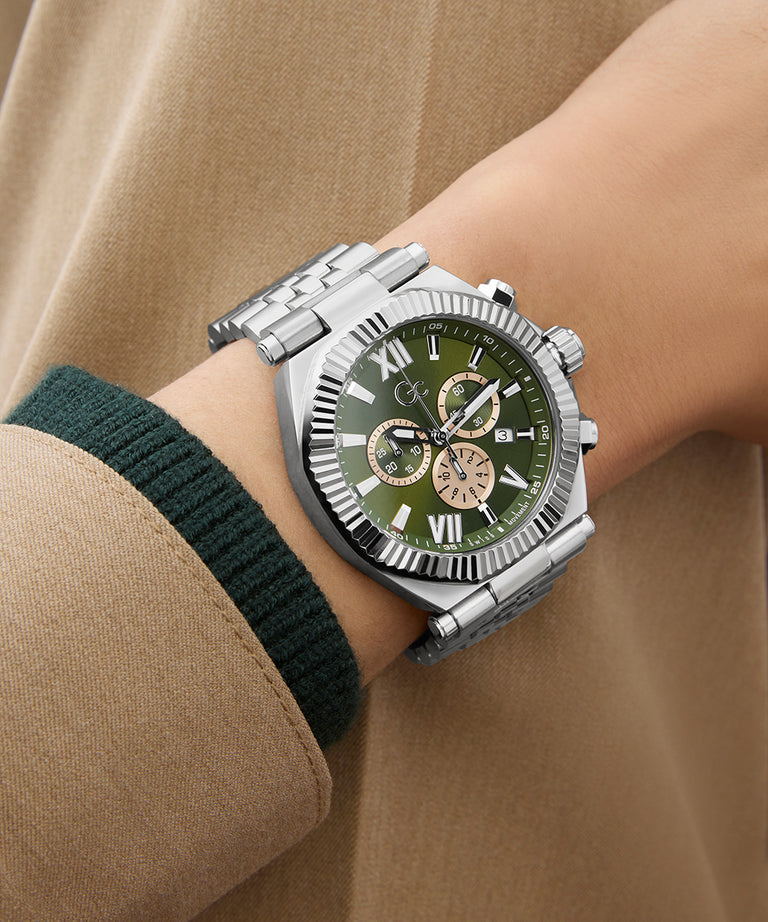  Gc Atlas Chrono Metal Green dial watch with silver case on a wrist against a beige background