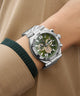  Gc Atlas Chrono Metal Green dial watch with silver case on a wrist against a beige background