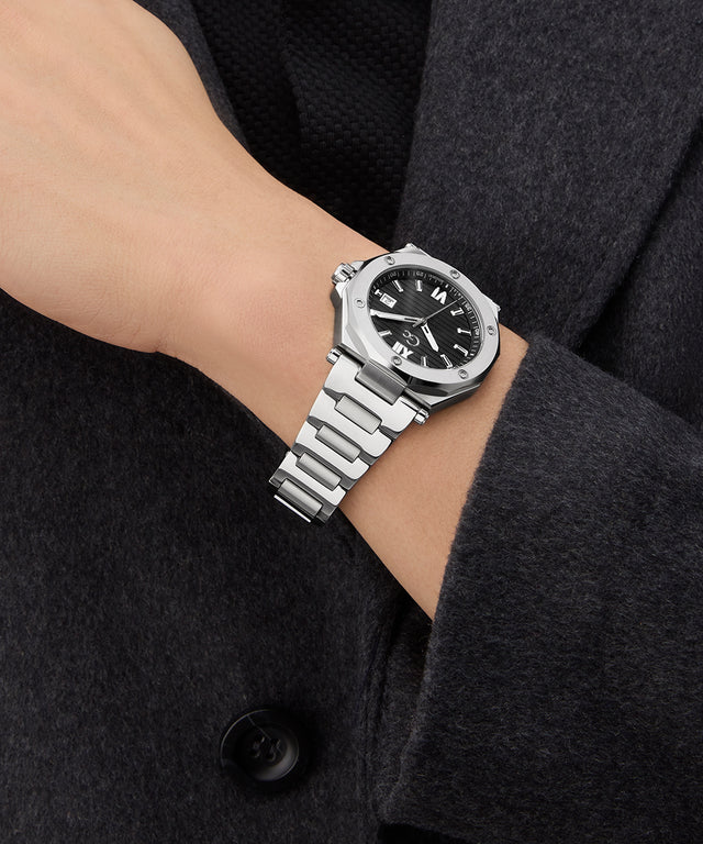 Gc Legacy Sleek Metal watch on a wrist with a dark coat background