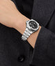 Gc Legacy Sleek Metal watch on a wrist with a dark coat background
