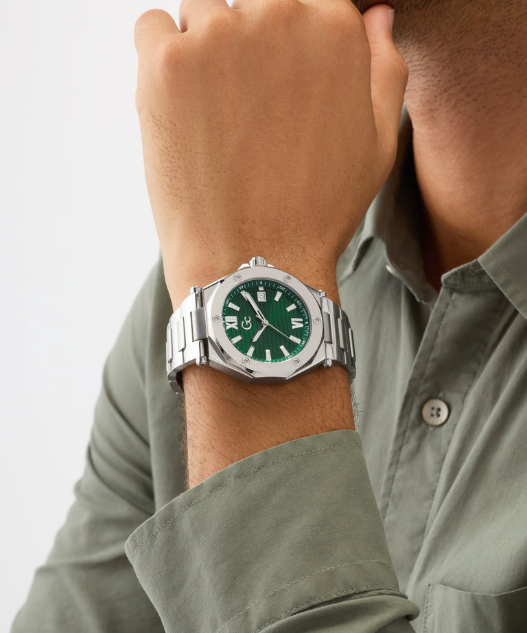 Person wearing a silver Gc Legacy Sleek Metal with a green face on a light gray background